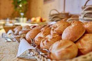 A buffet table with an assortment of breads and pastries.