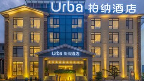 Un hotel con fachada moderna, destacando un cartel con el nombre 'Urba'.
