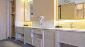 A modern bathroom with a large mirror, two sinks, a hairdryer, and storage cabinets. - Urba Hotel Chacheng Pu'er (Pu'er)