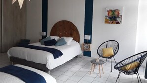 A bedroom with a bed, a star-shaped light fixture, a chair, and a small table.
