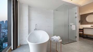 Une salle de bain moderne avec une baignoire sur pieds, une douche à parois de verre et un meuble-lavabo avec un miroir.