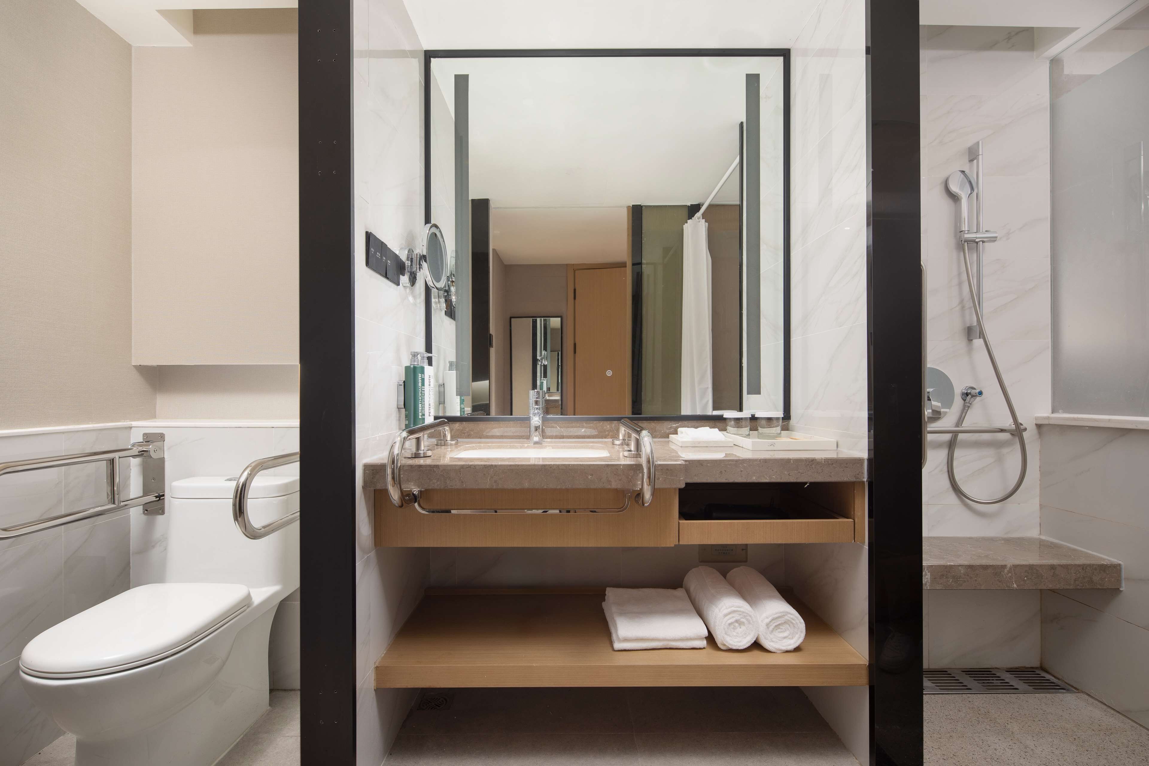 Ein modernes Badezimmer mit Toilette, Waschbecken und Dusche.