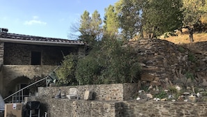 A stone building with a tiled roof, a stone wall, and a small pool area. - 12-person house with swimming pool, covered terrace, barbecue, shops nearby (Le Martinet)