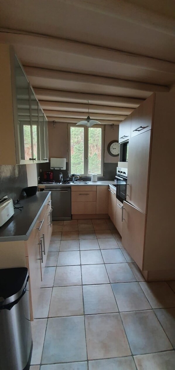 A compact kitchen with a sink, stove, and cabinets. - 12-person house with swimming pool, covered terrace, barbecue, shops nearby (Le Martinet)