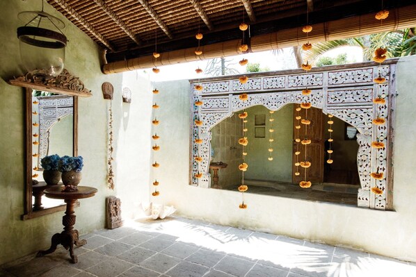 An ornate doorway with intricate carvings and hanging floral decorations.