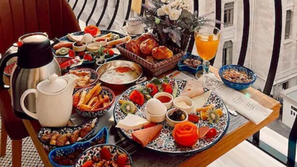 Un balcón con una mesa lista para el desayuno, con vistas a edificios históricos.