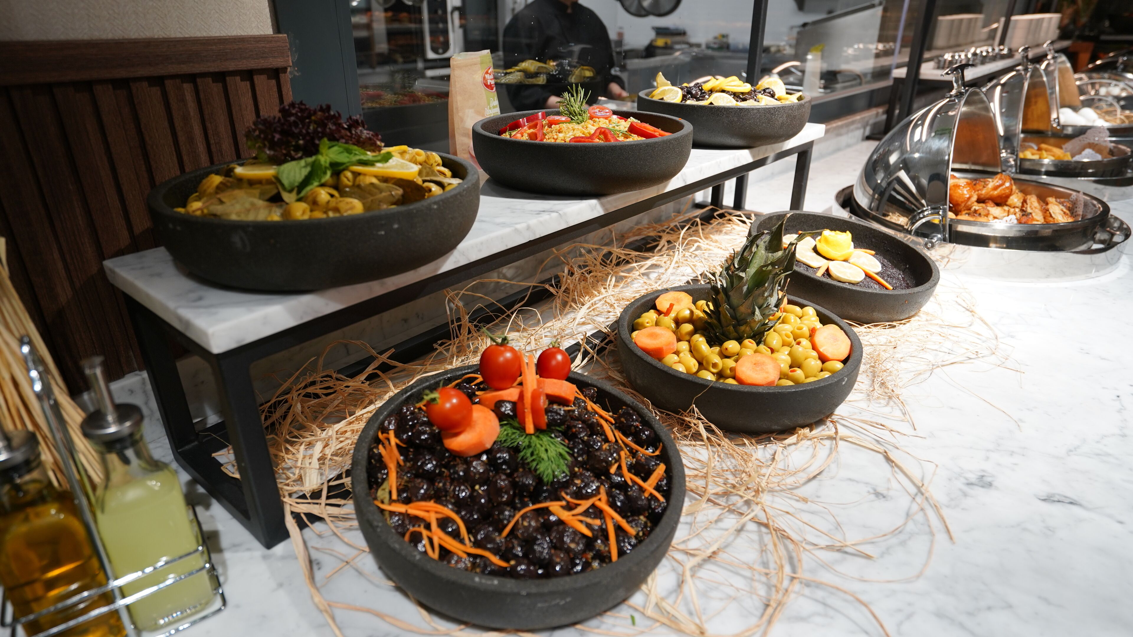 A buffet with various dishes, including salads, pasta, and a pineapple centerpiece.