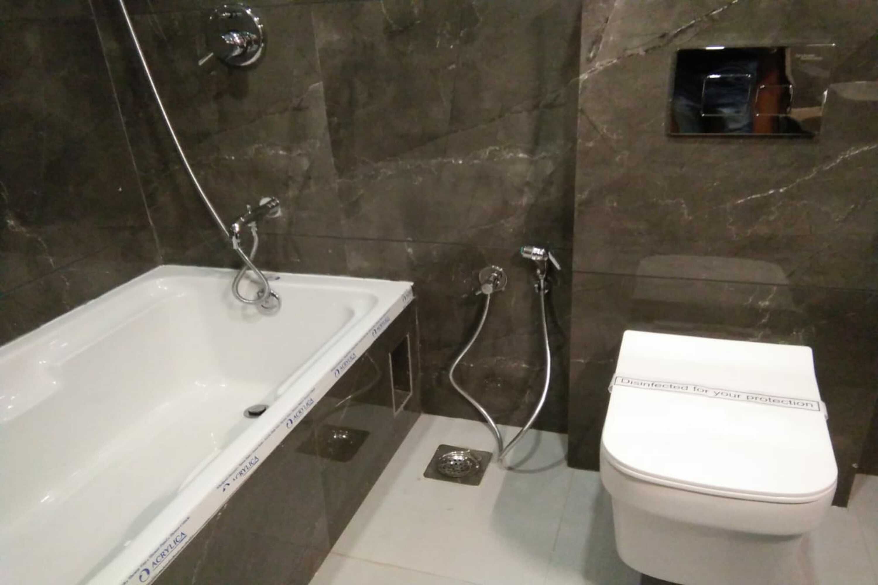 Un baño con bañera, inodoro y ducha.