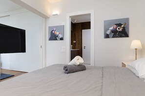 A hotel room with a bed, a TV, and two paintings on the wall. - Duplex 2 bedroom with a terrace (Tel Aviv)