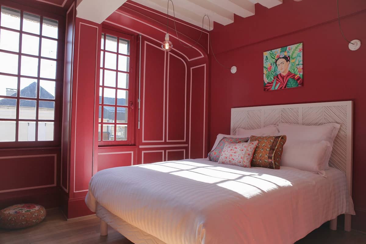 Ein Schlafzimmer mit einem großen Bett, einem Fenster mit Blick und einem Bild an der Wand.