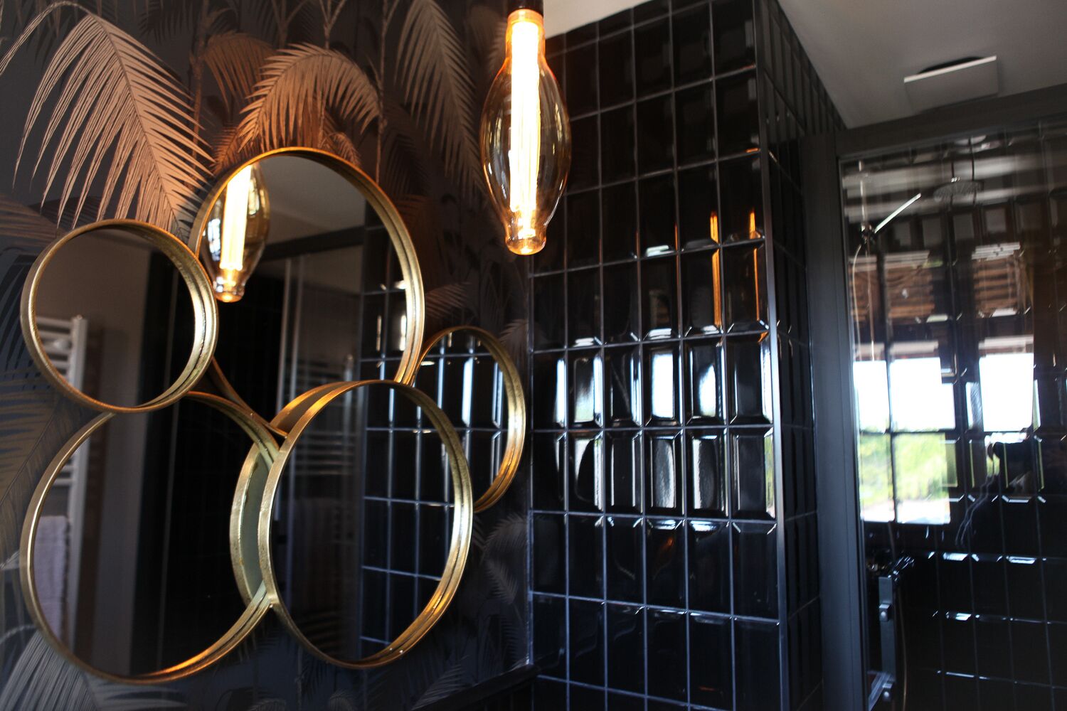 A wall with circular mirrors and a grid-patterned black panel.