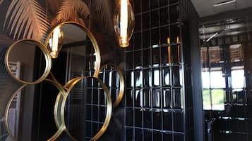 A wall with circular mirrors and a grid-patterned black panel.