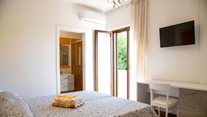 Ein Schlafzimmer mit Bett, Schreibtisch und Fernseher.