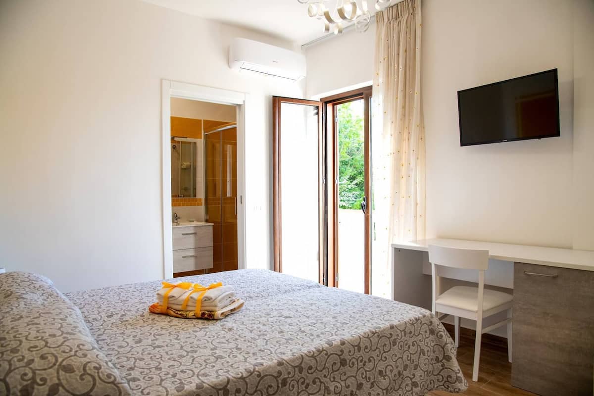 Ein Schlafzimmer mit Bett, Schreibtisch und Fernseher.