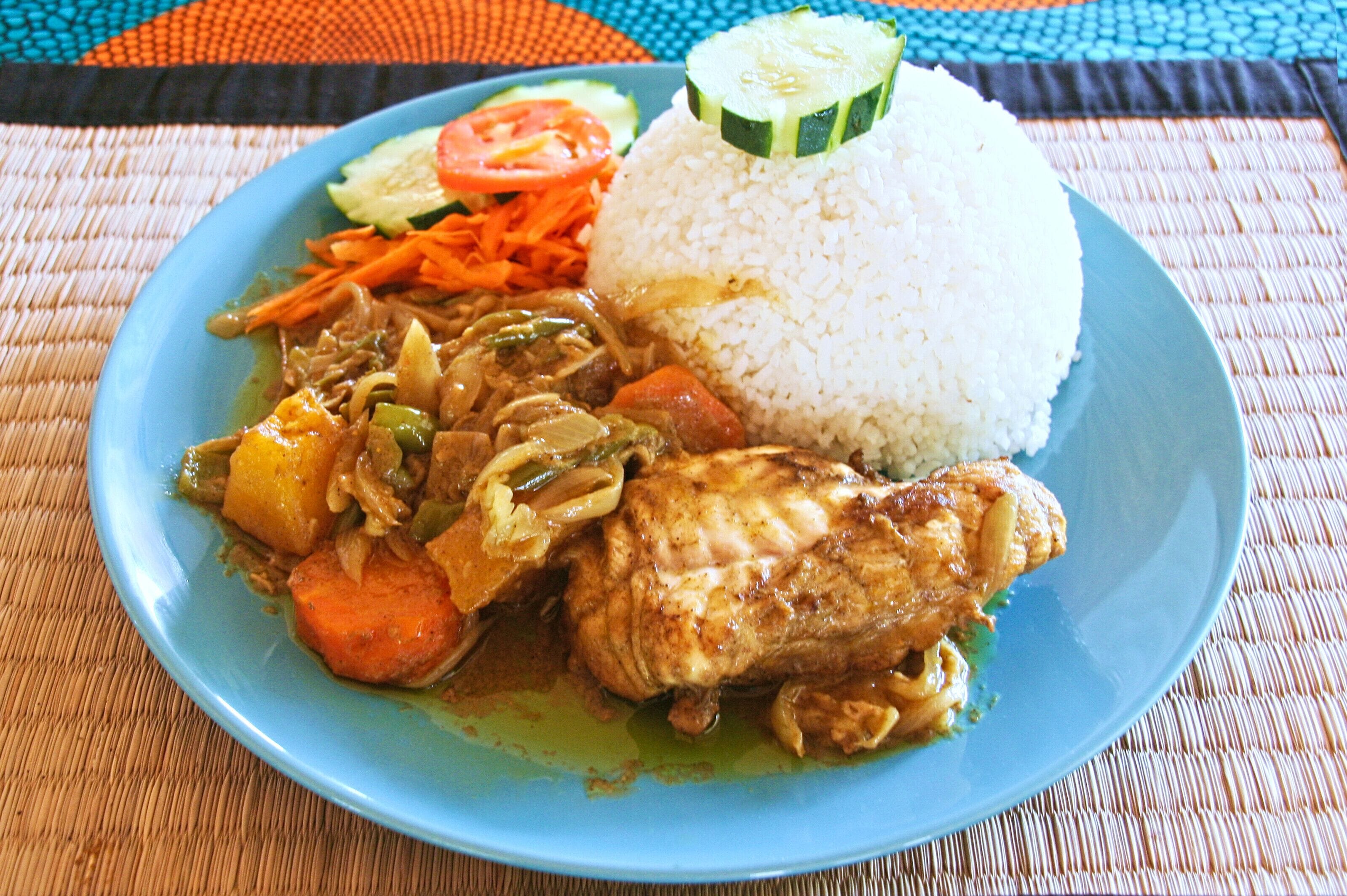 Un plato de arroz, pollo y verduras.