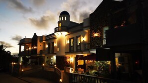 A hotel with a central tower, multiple balconies, and a stone facade. - Pension Ivatan (Basco)