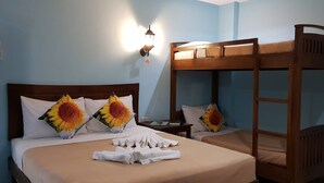 Ein Hotelzimmer mit Etagenbett, Nachttisch, Lampe und Handtuch auf dem Bett.