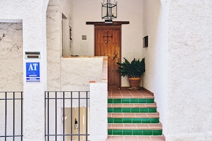 A building entrance with a wooden door, a potted plant, and a sign indicating a rural apartment building. - House with views of scandal and two terraces in Parque de Cazorla and Segura, 6pax (Segura de la Sierra)