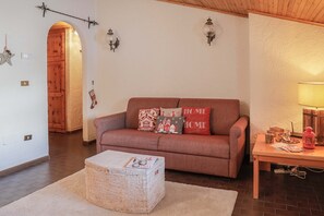 Uma sala de estar acolhedora com um sofá marrom, uma mesa de madeira e uma cesta de vime.