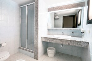 A bathroom with a shower, toilet, sink, and a mirror above the sink. - Club Hotel Marina Seada Beach (Budoni)
