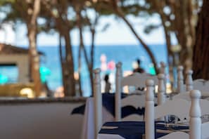 A table set for dining with a view of the sea.