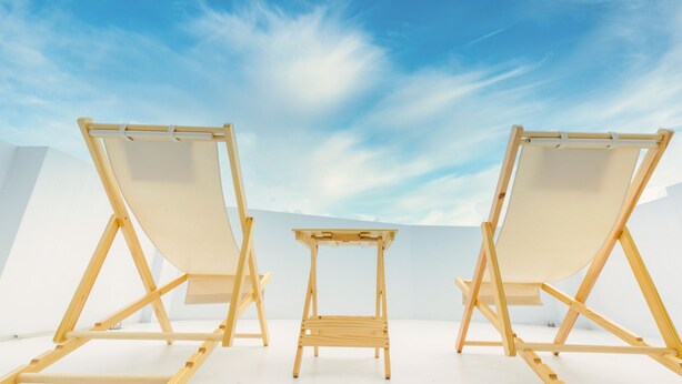 Three wooden easels on a white floor with a clear blue sky in the background.