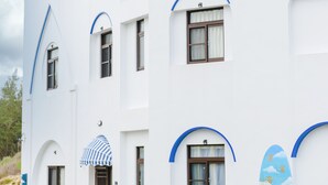 A white building with blue trim and arched windows.