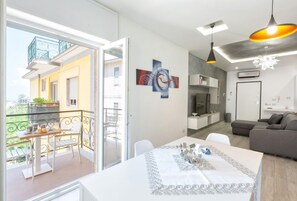 Un apartamento moderno con balcón, comedor y sala de estar.