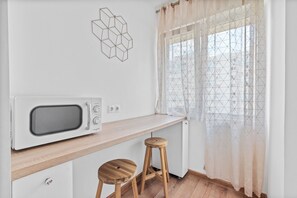 Deluxe appartement | Privékeuken | Een koelkast met diepvriezer, een microgolfoven, een kookplaat