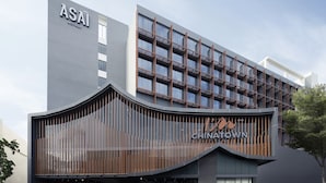 Un hôtel moderne, avec une enseigne ASAI HOTELS bien visible sur le côté supérieur gauche.