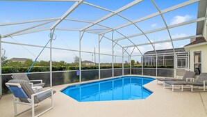 A covered outdoor swimming pool with lounge chairs, a clear view of the surrounding landscape, and a security sign. - Malaki (Davenport)