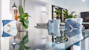 A modern living room with a glass coffee table, a sofa, and decorative items. - Cubo's Cozy & Modern Sol de Malaga / Private pool / Free Wifi (Málaga)