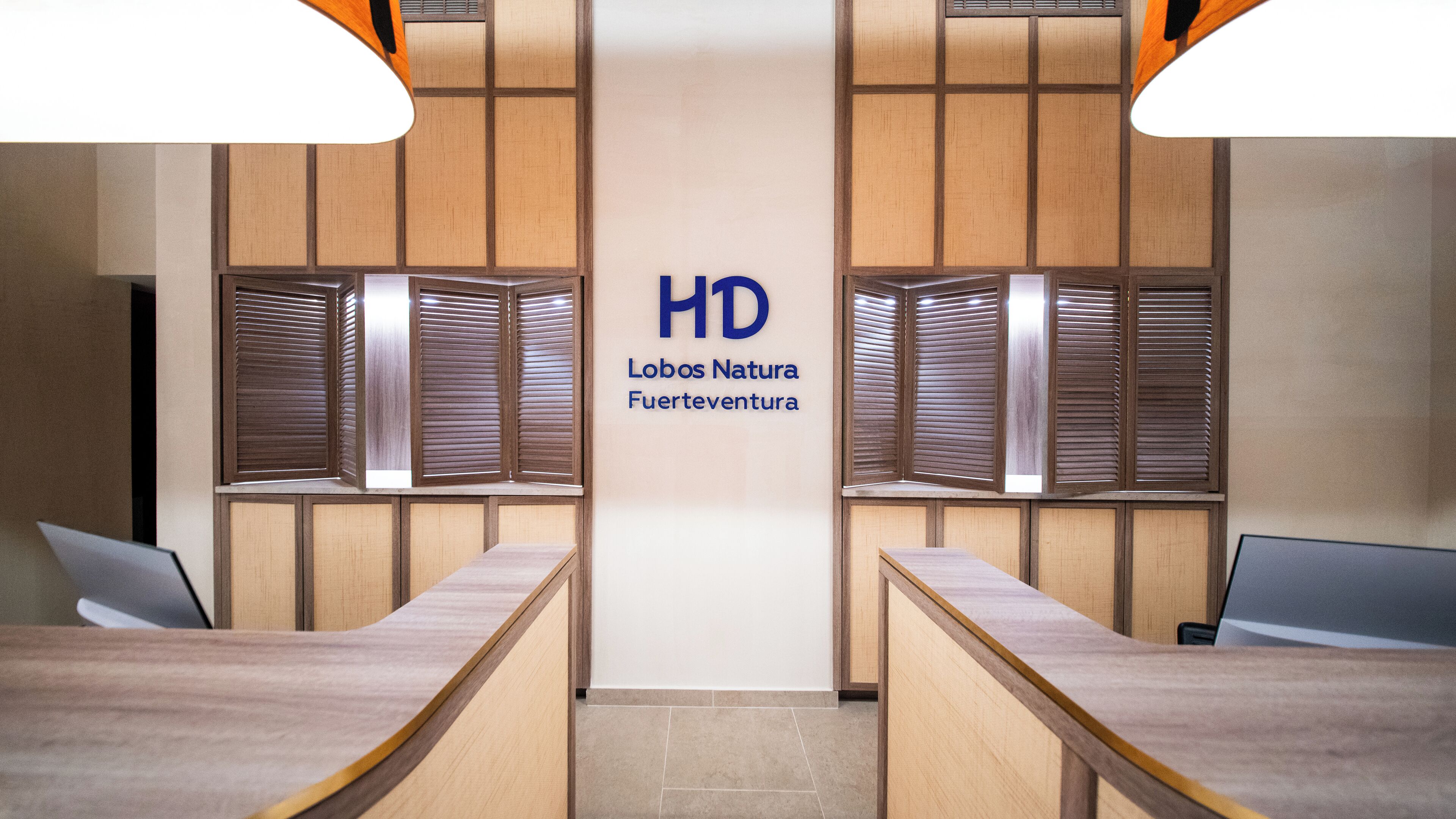 A reception area with wooden paneling, a central HD logo, and two reception desks.