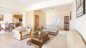 A living room with a sofa, two armchairs, a coffee table, and a dining area with a table and chairs. - Charming Seaside Villa in South Rhodes (Blue Pearl)  (Gennadi)