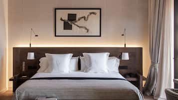 A hotel room with a large bed, a ceiling fan, a bedside table with a lamp, a framed picture on the wall, and a window with curtains.