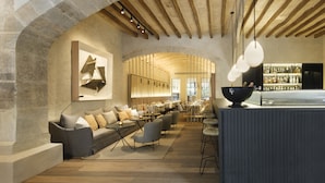 A modern interior with a stone archway, a bar area, and a seating area with sofas and tables. - Can Ferrereta (Santanyi)