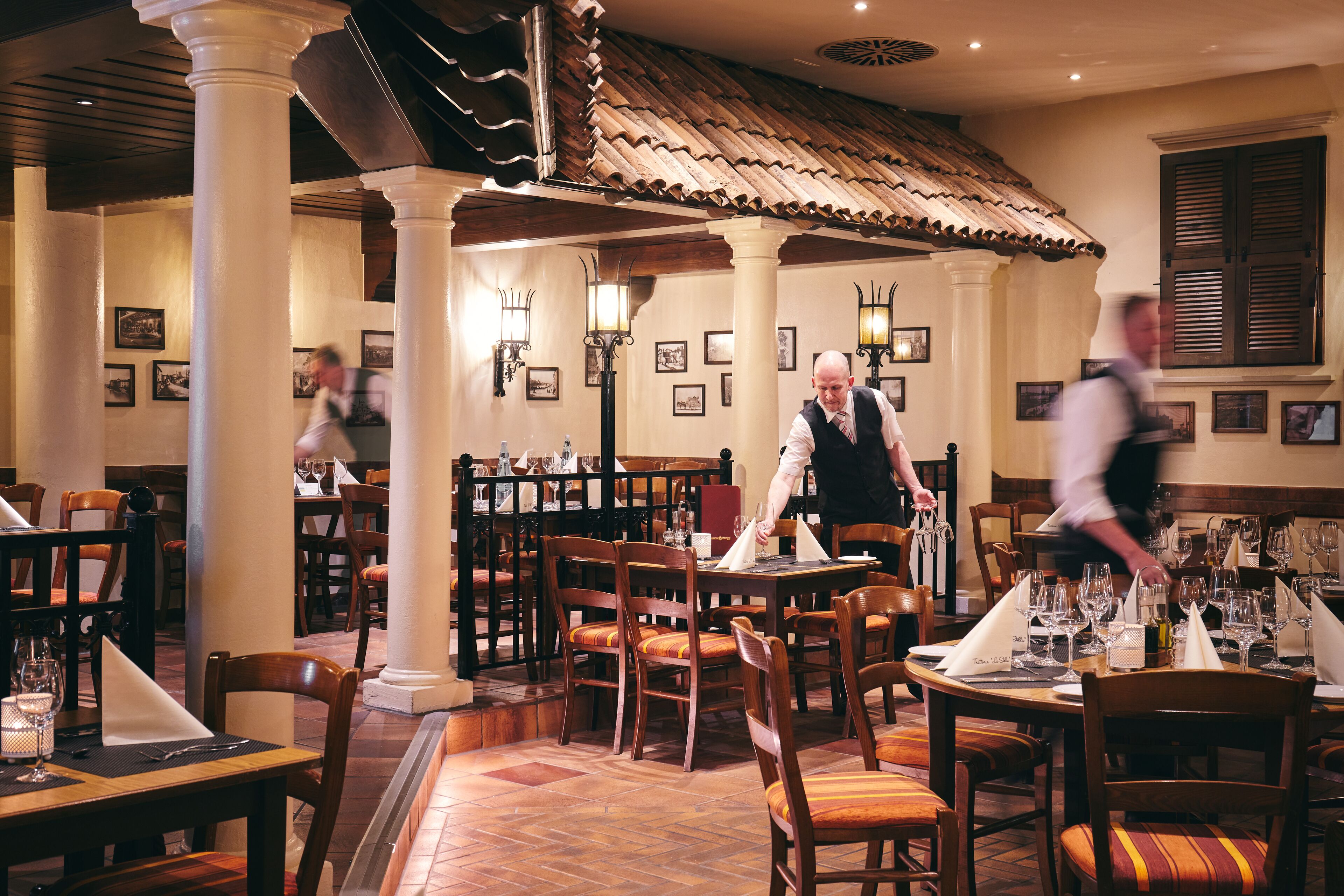 L’intérieur d’un restaurant avec des tables et des chaises en bois, ainsi qu’un sol carrelé.