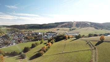 A rural town with a mix of residential and commercial buildings, surrounded by rolling hills and fields.