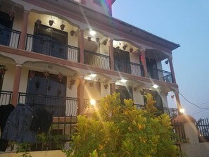A multi-story building with balconies, hanging plants, and a well-lit entrance. - Inland Motel Kampala (Kampala)