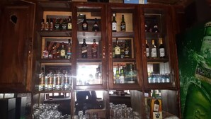 Eine Bar mit Regalen voller Spirituosenflaschen und Gläsern.