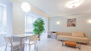 A modern living room with a glass coffee table, a beige sofa, and a dining area with a white table and chairs. - Newly renovated spacious perfectly located at Baseina str. (Kyiv)