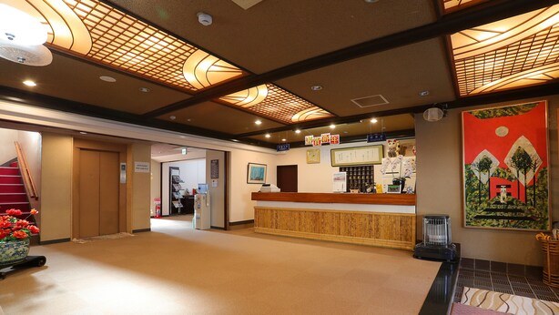 A hotel lobby with a reception desk, a staircase, and a decorative ceiling. - Raki Onsenryokan (Yamanouchi)