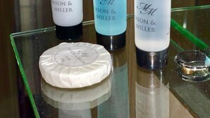 Tres productes d'estètica facial de MASON & MILLER sobre una prestatgeria de vidre.