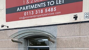 A building entrance with a sign advertising apartments for rent.
