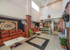 A spacious lobby with a leather sofa, a reception desk, and a large decorative wall. - Regenta Central Residency (Pattaya)