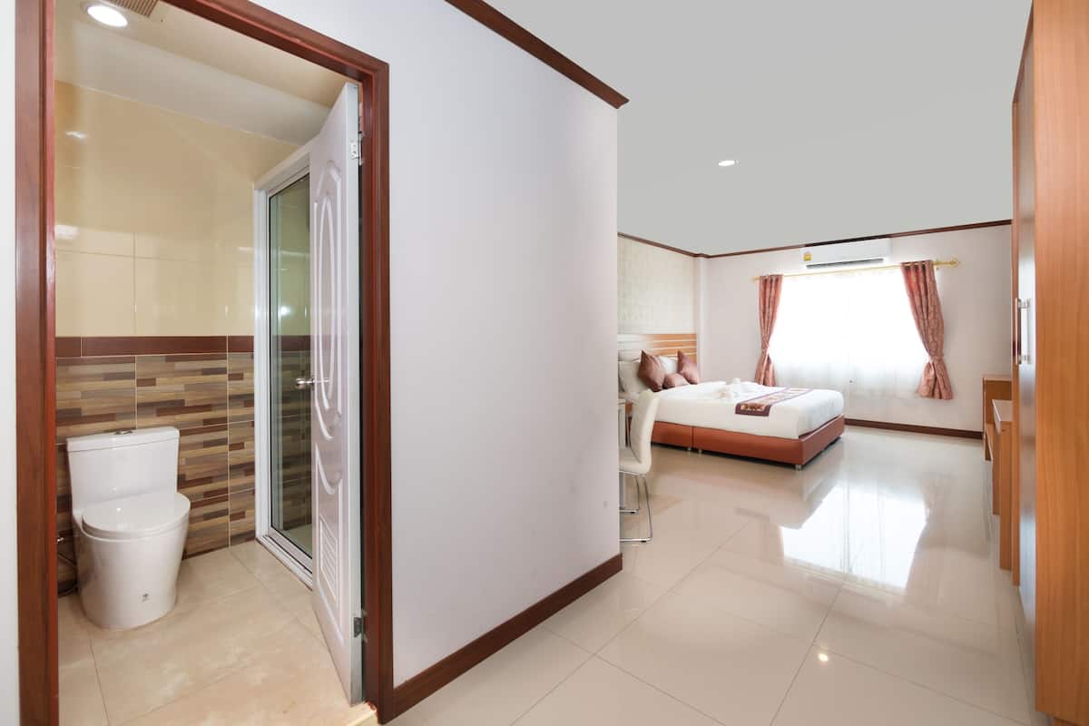 Quarto de hotel com casa de banho, cama e porta deslizante.