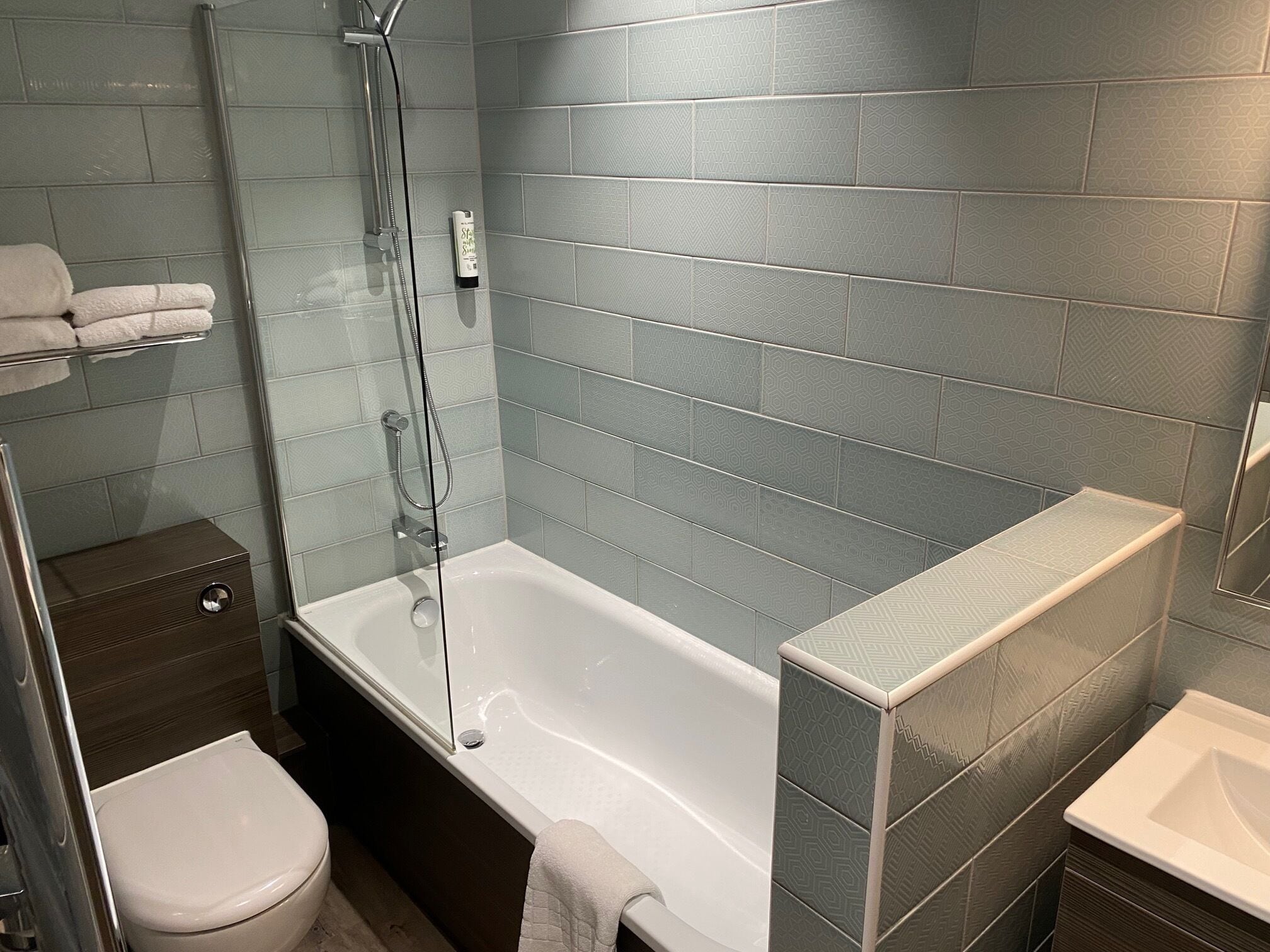 A modern bathroom with a bathtub, a toilet, and a shower area.