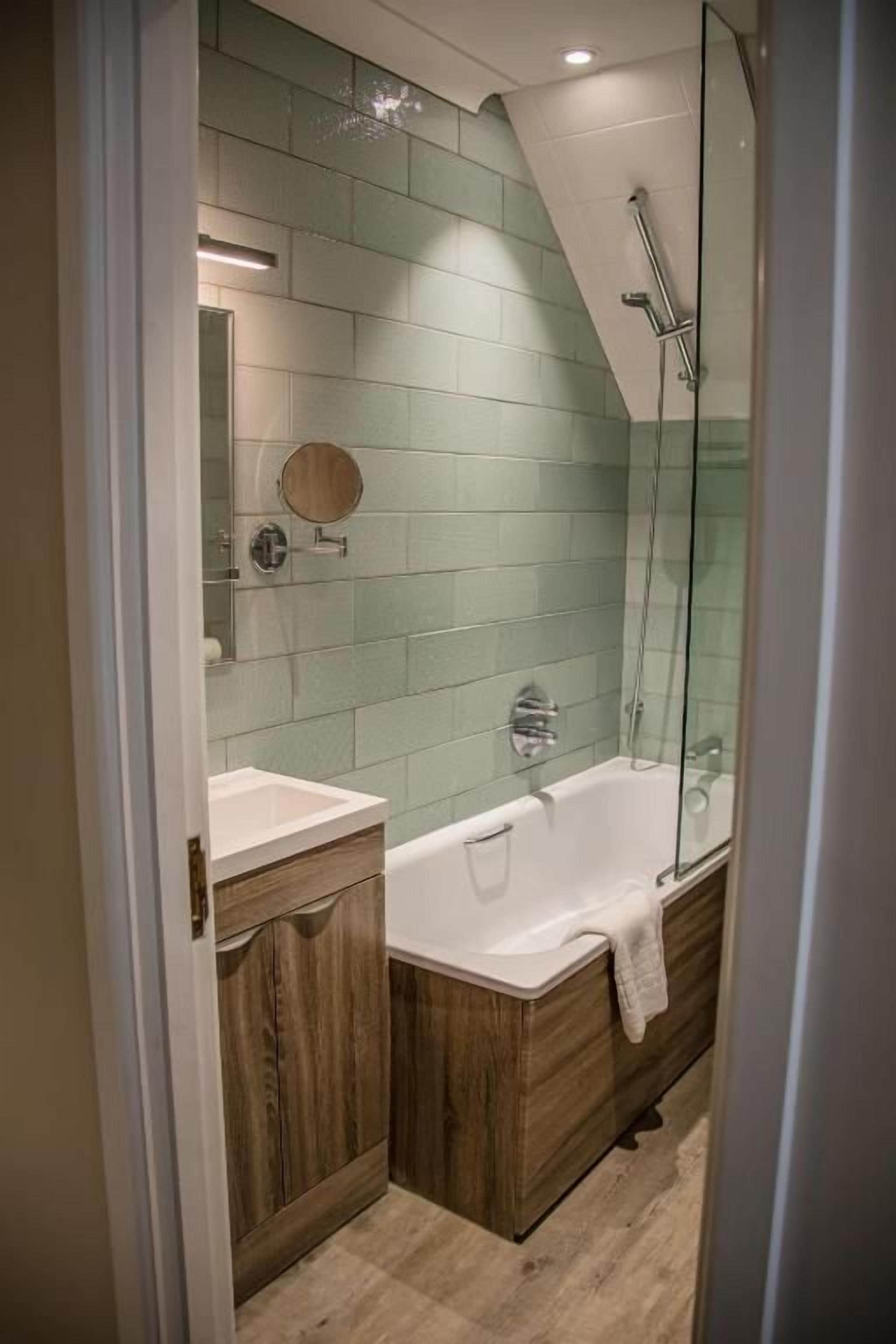 Un baño con bañera, ducha y tocador con espejo.