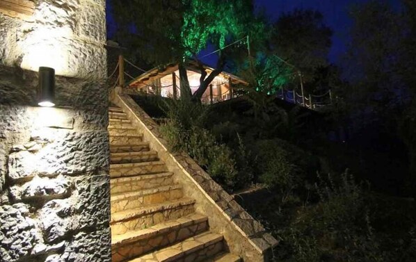 A stone staircase leading to a wooden cabin with a light source at the top. - Almond House Suites Arachova - Adults Only (Distomo-Arachova-Antikyra)