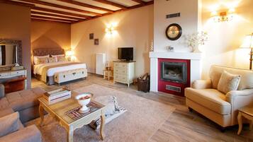 A spacious living room with a fireplace, a comfortable sofa, a coffee table, and a television.